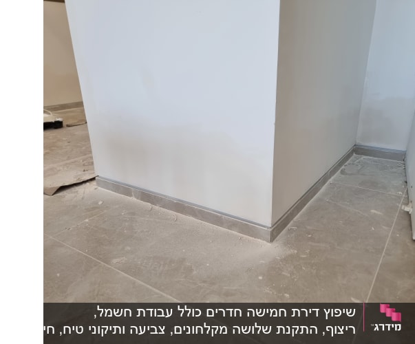 פינת קיר עם ריצוף חדש ופסי חיפוי